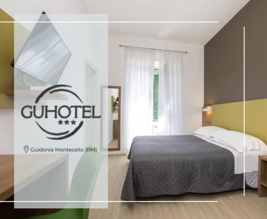 Camera moderna con letto matrimoniale, TV e scrivania a Guidonia Montecelio.